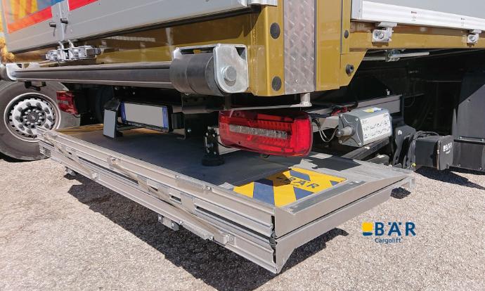 Onderrijdbare Bar-laadbrug in rijpositie op een parkeerplaats